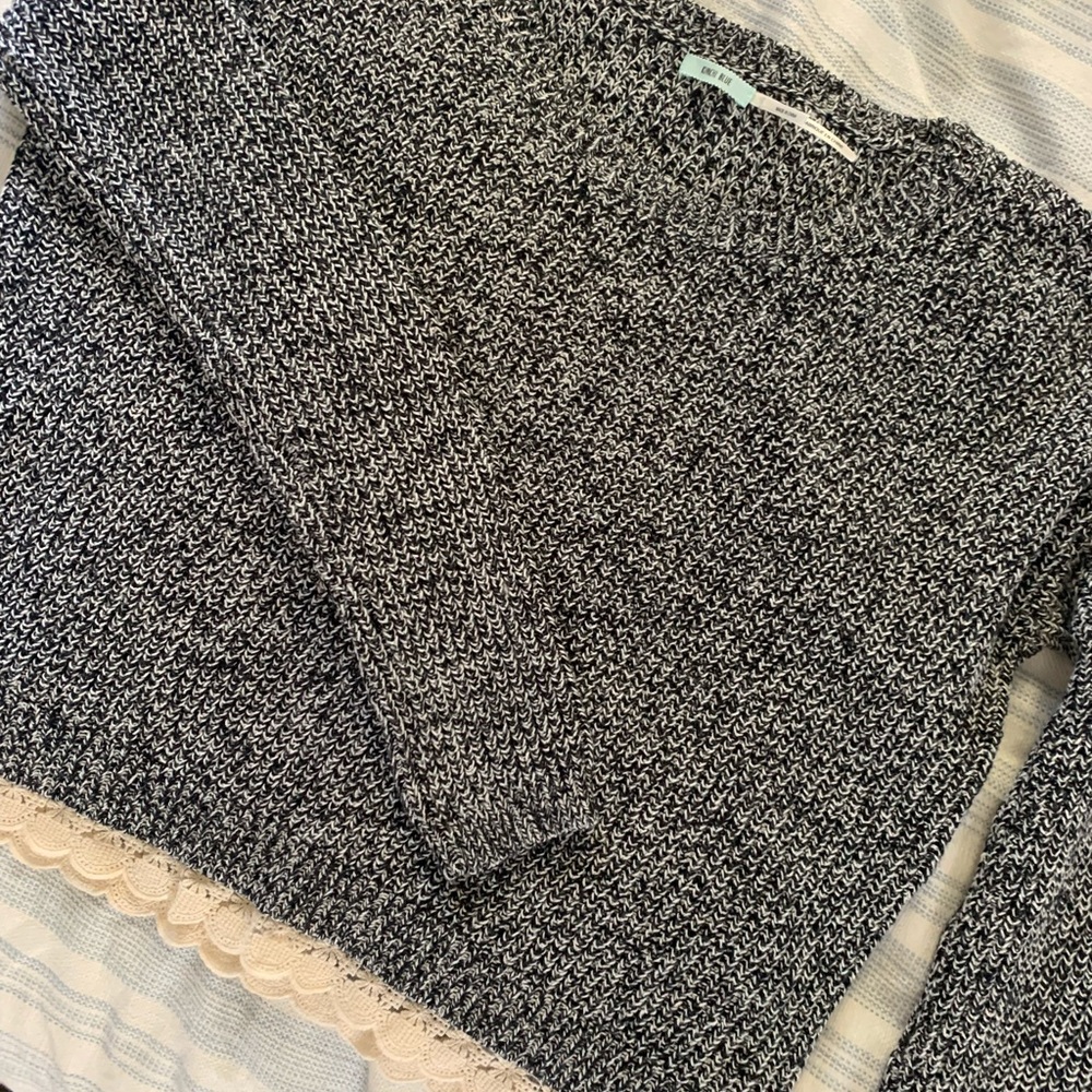 Black & white knit sweater with lace trim.